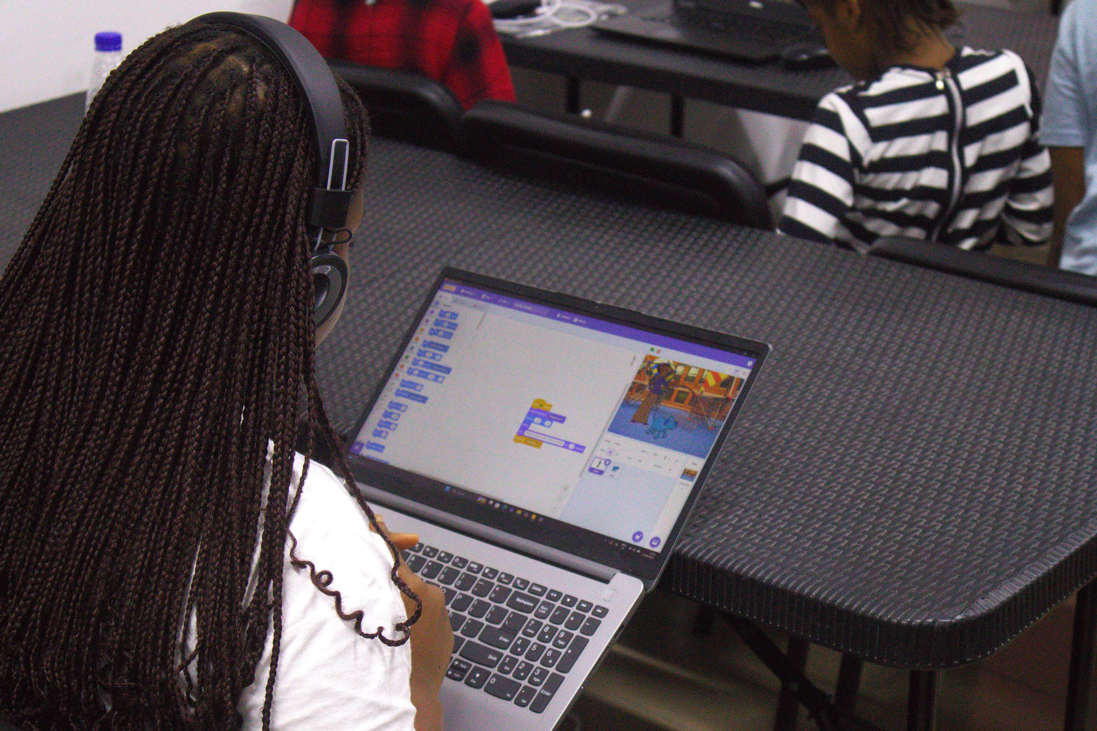 Children learning to code on laptops in a classroom